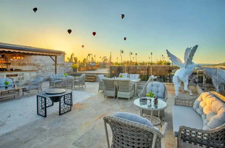 Kapadokya Pegasos Cave Hotel terasında balon manzarası ve oturma alanı